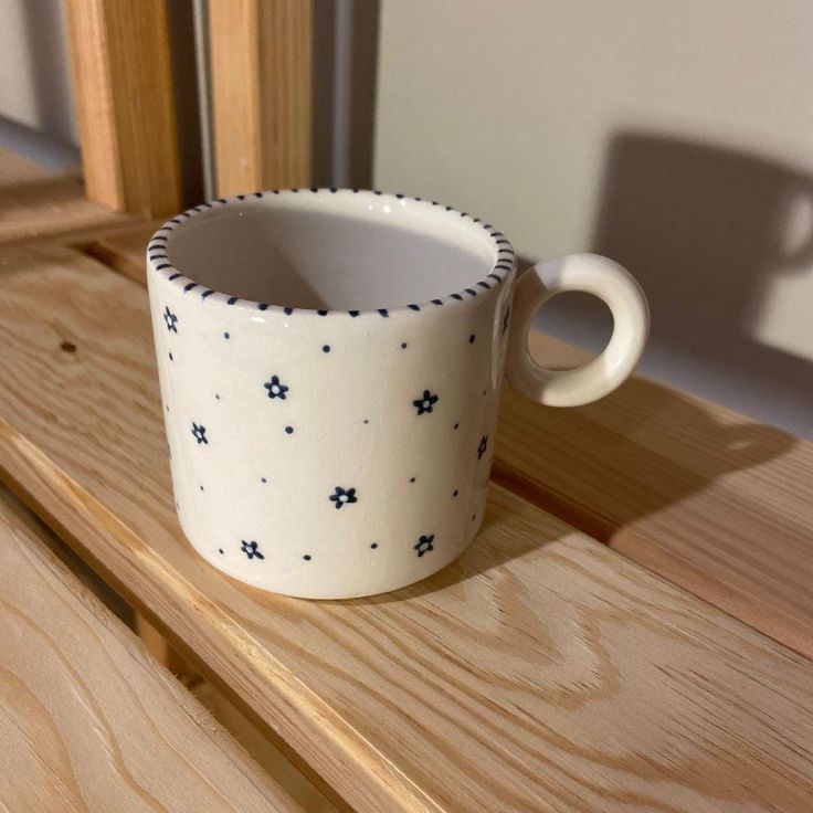 a white cup sitting on top of a wooden table