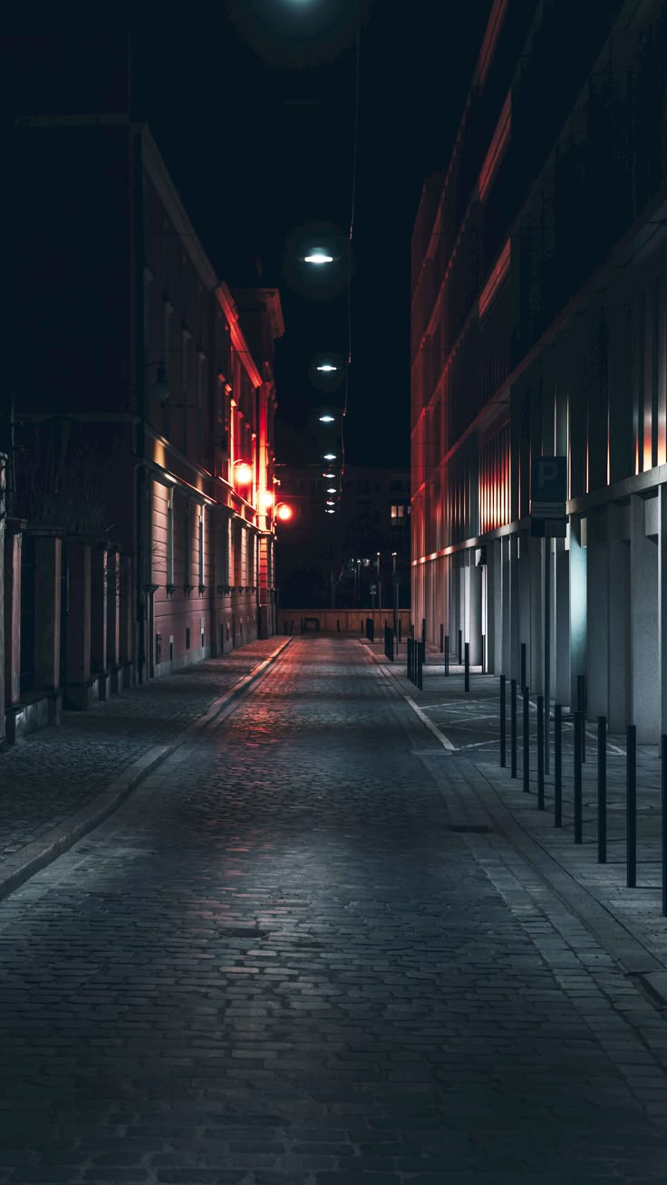 an empty city street at night with the lights turned on and no people in it