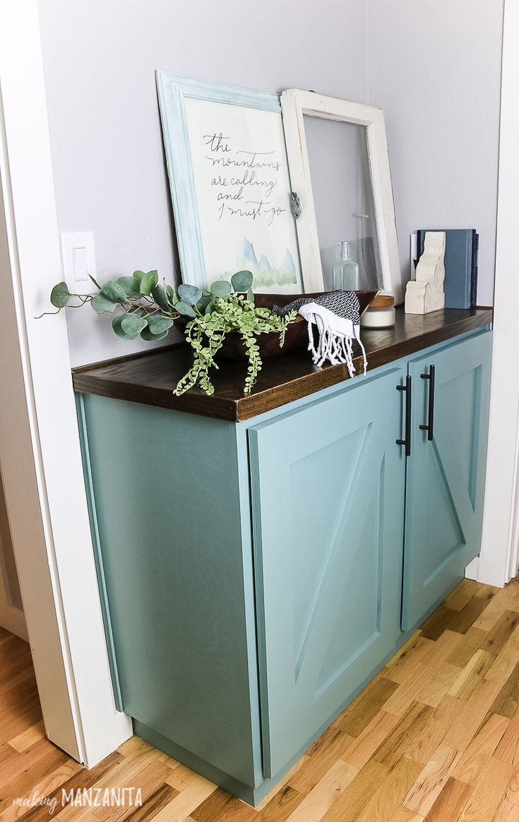 a blue cabinet sitting on top of a hard wood floor next to a white wall