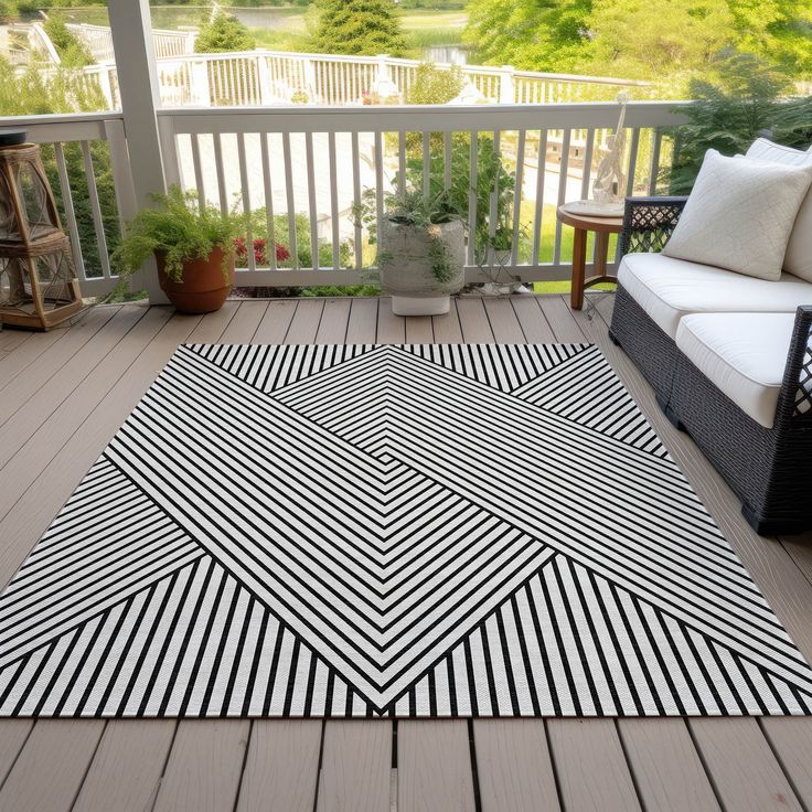 a black and white rug sitting on top of a wooden deck