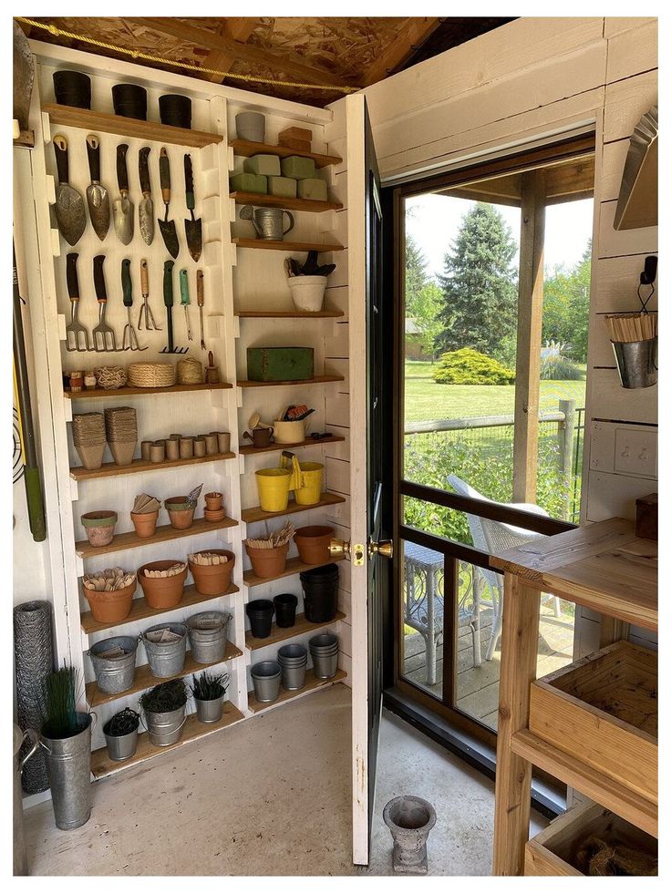 a kitchen with pots and pans hanging on the wall next to an open door