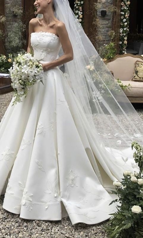 a woman in a wedding dress standing outside