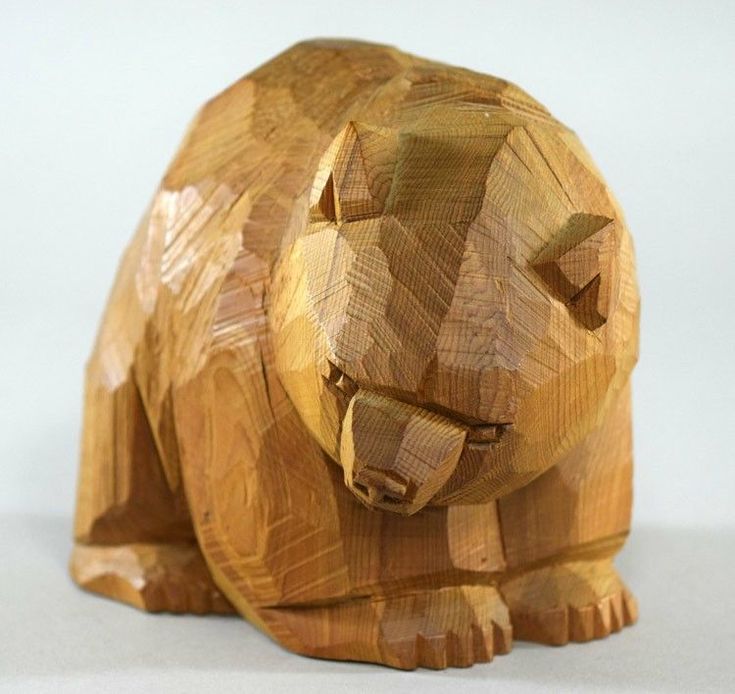 a carved wooden bear sitting on top of a table