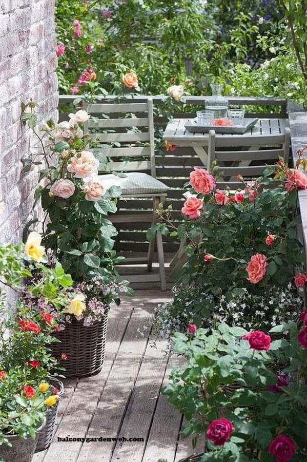 an outdoor patio with flowers and chairs