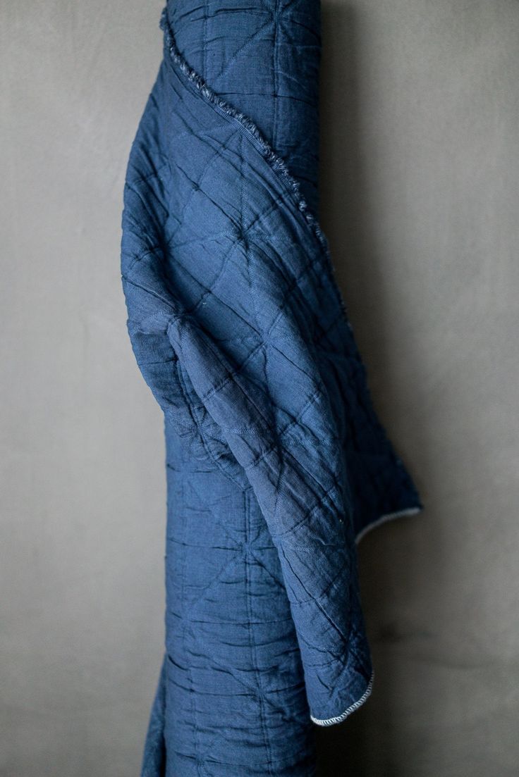 a blue blanket hanging from the side of a wall