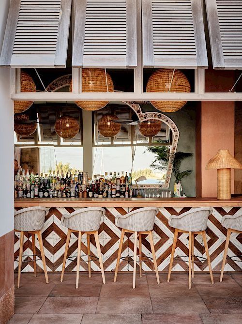 the bar is lined with chairs and bottles