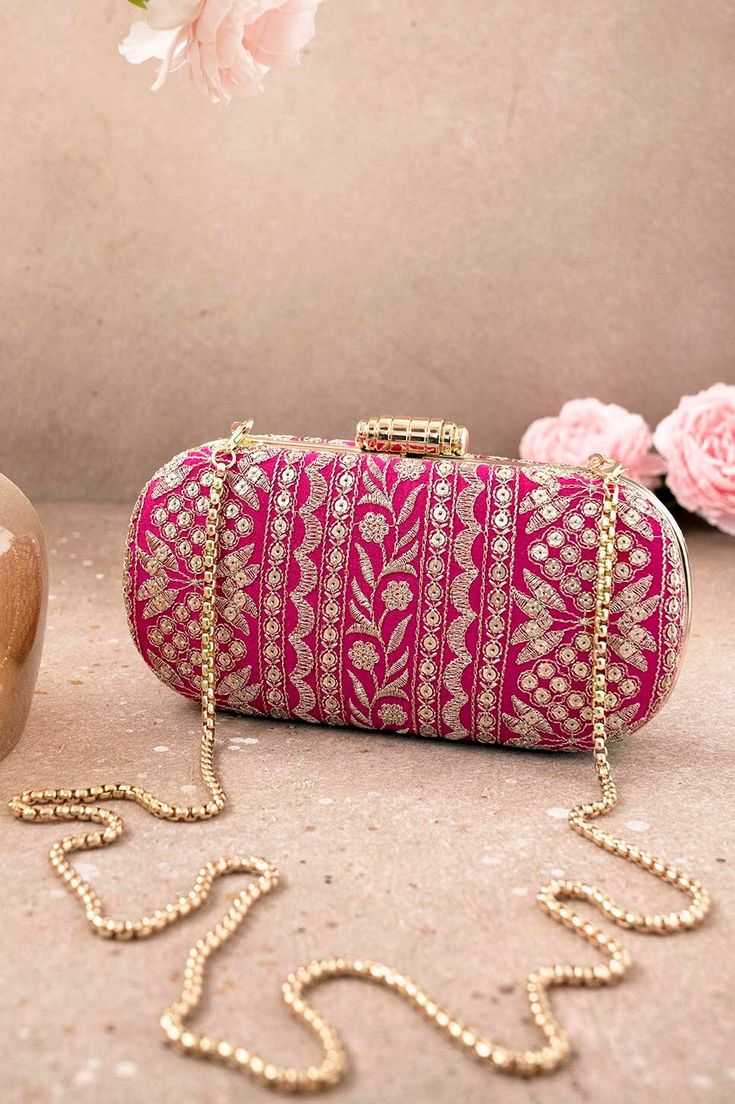 "Put together the perfect wedding look with our Mirai Embroidered clutch. This bag effortlessly delivers the Indian festive look. The luxe gold embroidery is a visual delight to the eyes. The gold tassels and the gold scallop lace add on to the grandeur of the bag. It's the perfect accessory for the bride to be who will be the center of attention.   Color: Pink with gold embroidery Dimensions (LxB): 8\"x4\" Handle length: 47\" Handle drop: 23\" Material: Embroidered poly silk, suede lining, golden metal clutch frame, golden metal sling. Features: metal lock closure, detachable metal sling." Luxury Wedding Clutch With Gold Embroidery, Luxury Gold Embroidered Clutch For Wedding, Traditional Gold Clutch With Gota Work, Festive Bollywood Potli Bag With Resham Embroidery, Festive Bollywood Resham Embroidery Potli Bag, Festive Bollywood Resham Embroidered Potli Bag, Embroidered Pouch For Reception, Embroidered Gold Potli Bag, Festive Gold Clutch With Gota Work