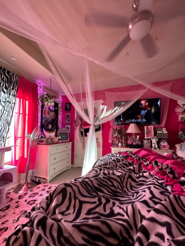 a bedroom decorated in pink and zebra print