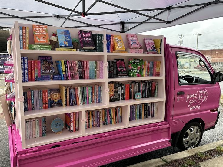 a pink truck with books on the back