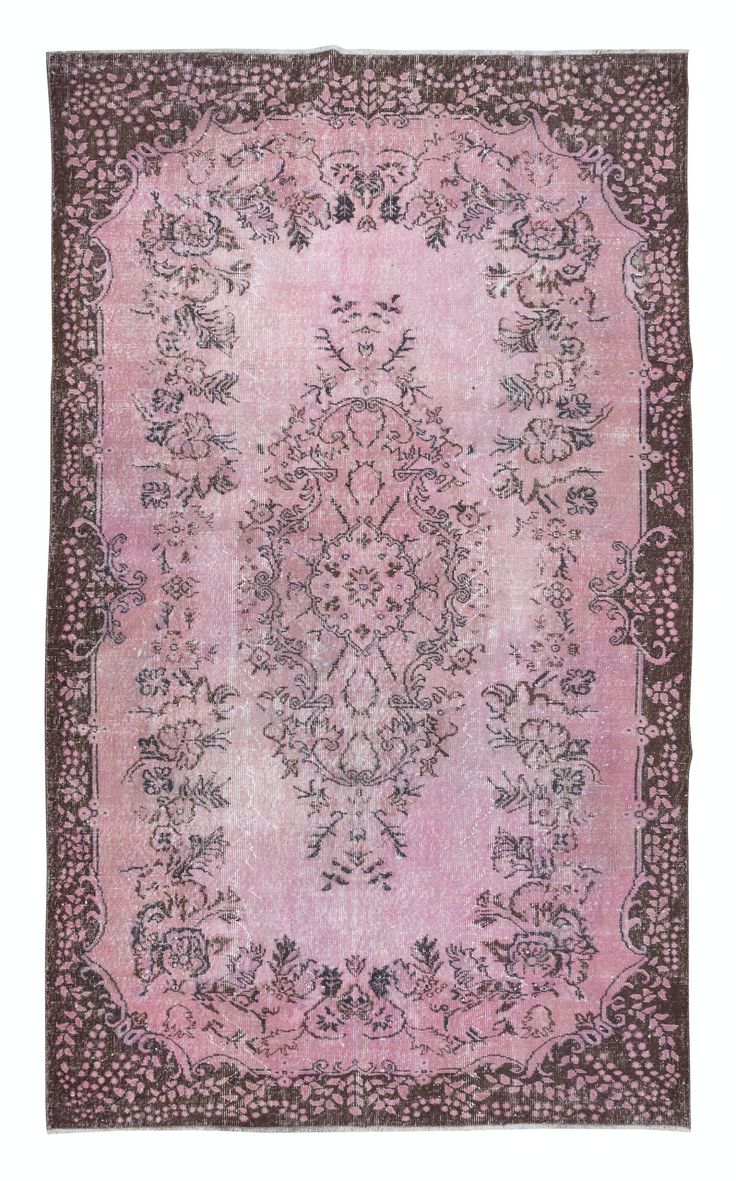 a pink rug with an ornate design on the center and sides, in various colors