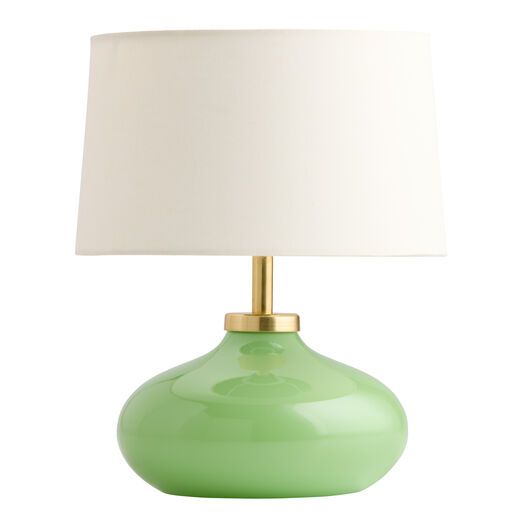 a green table lamp with a white shade