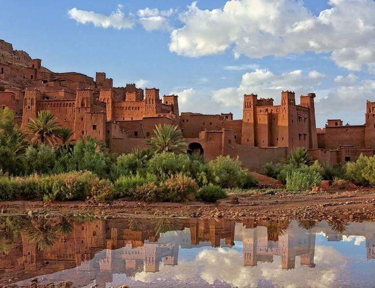 a castle like building is reflected in the water