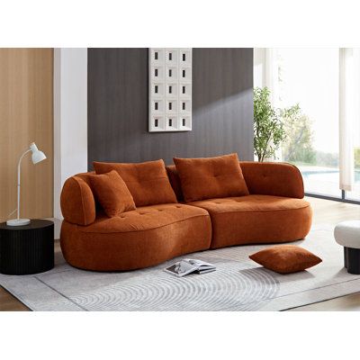 an orange couch sitting on top of a white rug