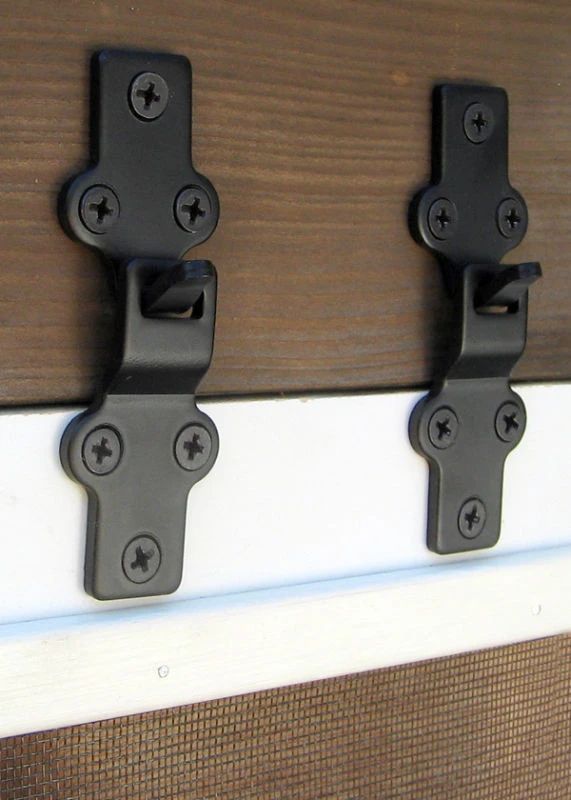 two black latches are attached to the side of a door