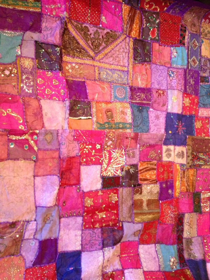 a colorful patchwork wall hanging on the side of a building with lots of different colors