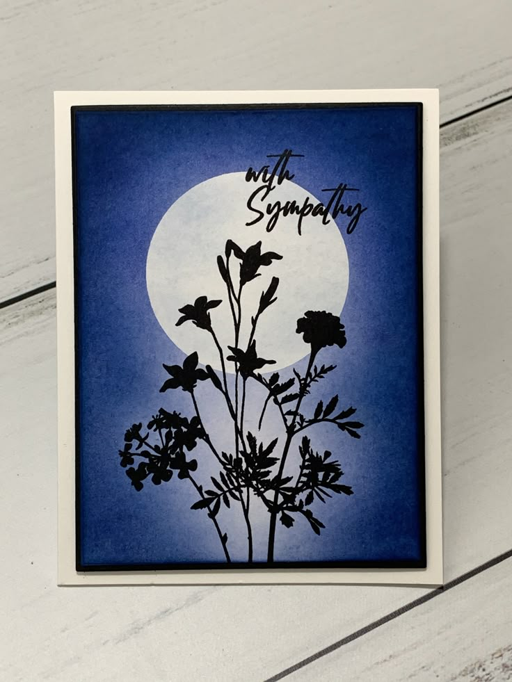 a card with the words, my sympathy written on it and flowers in front of a full moon