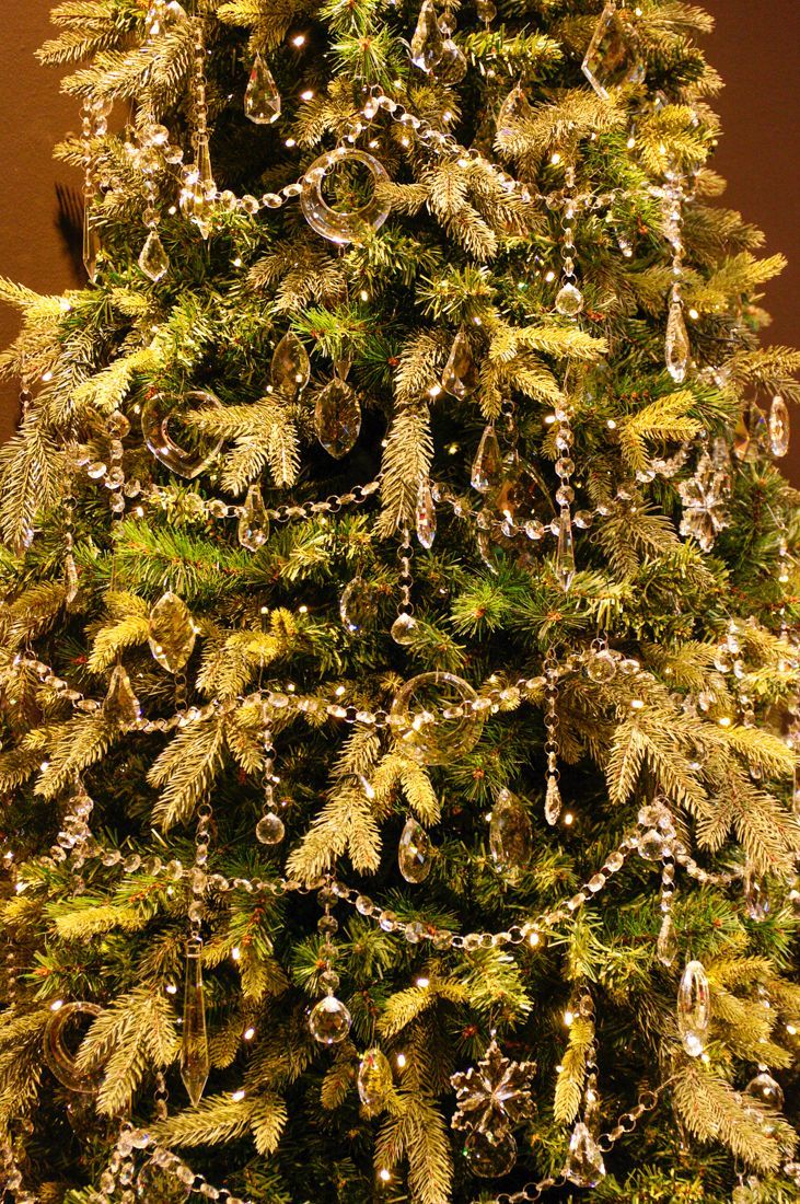 a christmas tree is decorated with gold and silver ornaments