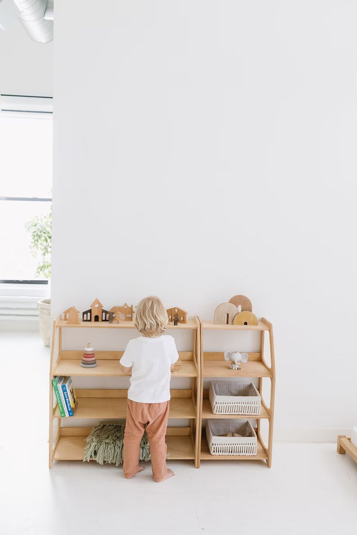 a small child standing in front of a book shelf