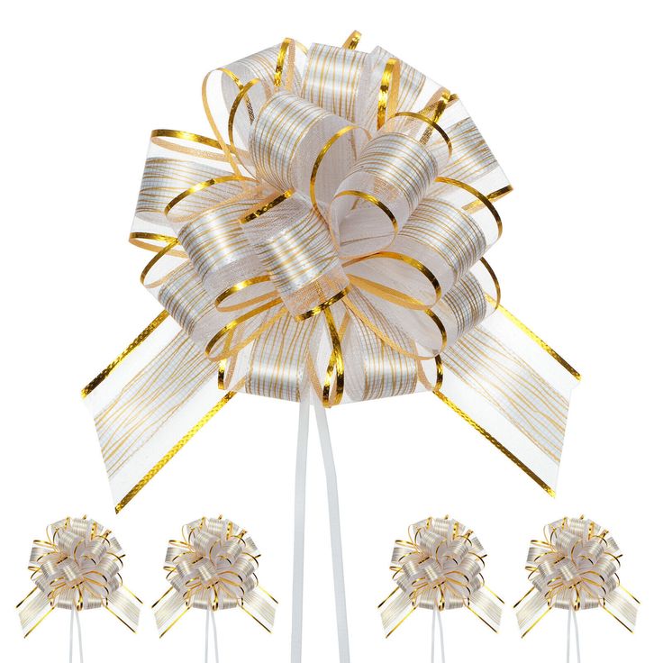 a bow on top of three lollipops that are gold and white in color