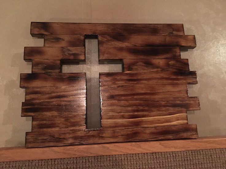 a wooden cross sitting on top of a shelf