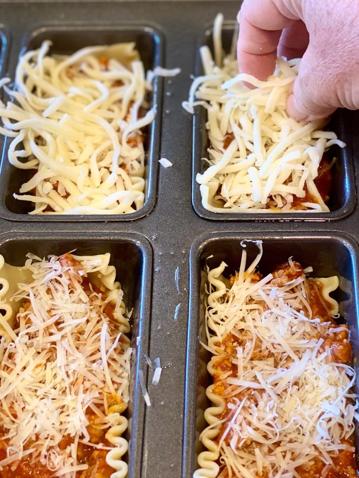 four trays filled with different types of pasta and cheese on top of each other