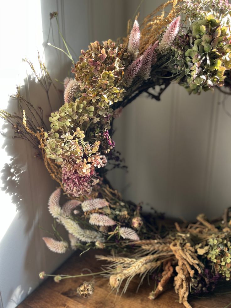 a dried wreath sitting on top of a wooden table