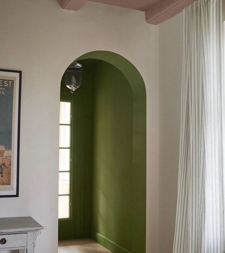 an arched doorway in the corner of a room with a painting on it's wall