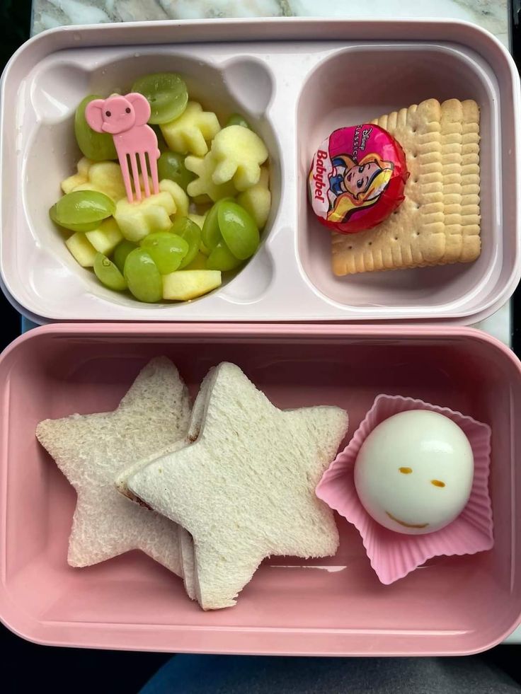 two pink trays filled with food on top of a table