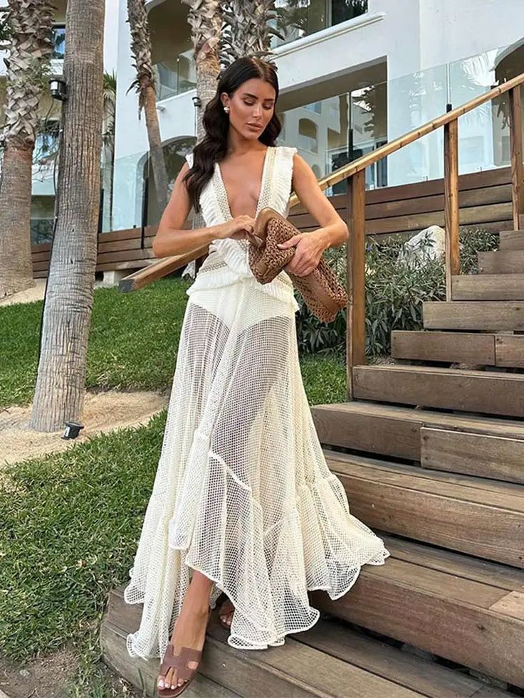 Experience effortless elegance in the Fringe and Mesh Cutout Maxi Dress. Featuring a deep V-neckline, irregular ruffled details, and a sleeveless design, this dress exudes modern sophistication. The hollow out and tassel accents add a touch of playful flair, making it the perfect choice for any fashion-forward woman. Summer V-neck Dress With Ruffled Skirt, Elegant V-neck Midi Dress With Ruffled Skirt, Elegant Sleeveless V-neck Dress For Beach, Sleeveless Dresses With Ruffled Skirt For Beach, Elegant Sleeveless Asymmetrical Dress With Ruffles, Sleeveless V-neck Summer Evening Dress, Sleeveless Dresses With Ruffled Skirt For Vacation, Chic Asymmetrical Summer Wedding Dress, Chic Summer Wedding Asymmetrical Dress