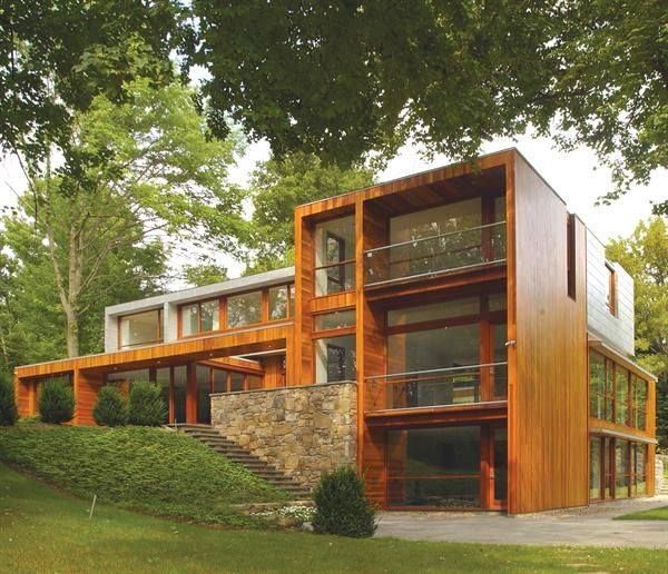 a large wooden house sitting on top of a lush green hillside