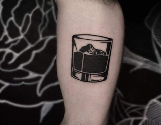 a black and white photo of a glass with ice cubes in it on the arm