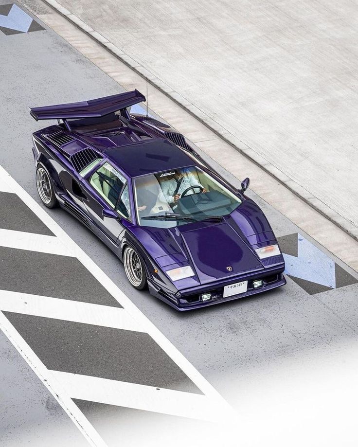 a purple sports car is parked on the street