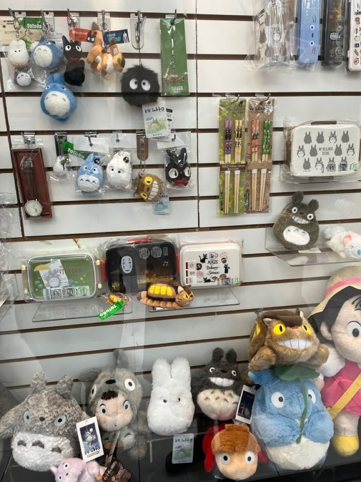 there are many stuffed animals on display in the store window, and one is holding a cell phone