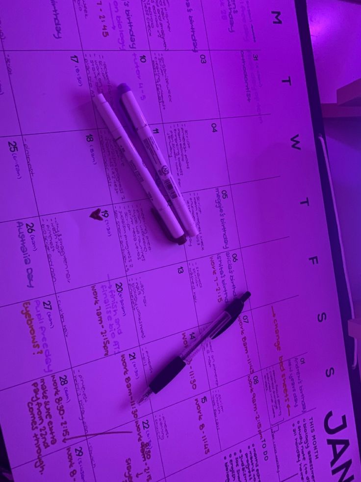 two pens sitting on top of a calendar