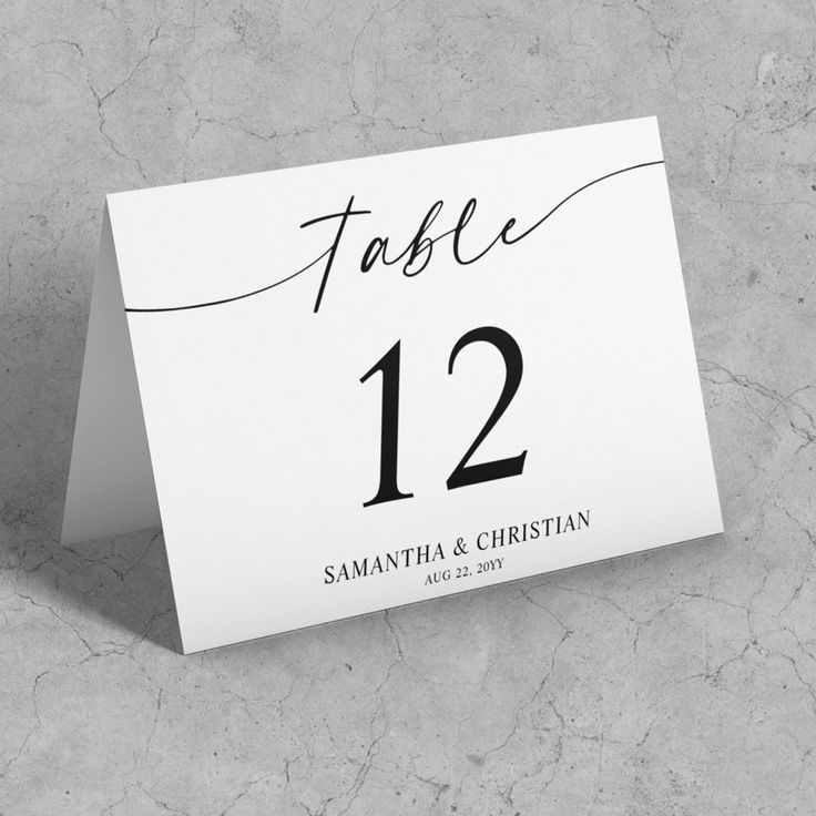 a place card with the number twelve on it is placed next to a marble surface