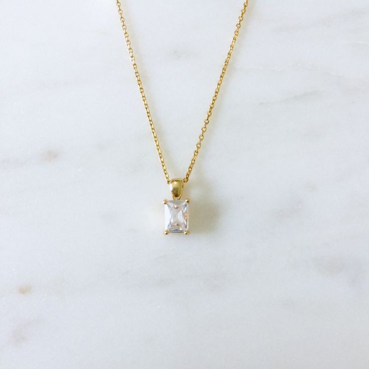 This is a dainty necklace with a small emerald cut CZ pendant. Perfect for everyday wear. Necklace Metal: 24K Gold filled Necklace Size: 16 in Pendant Metal : 18K Gold FilledPendant Size: 13 mm x 5 mm Pendant Stone: Cubic Zirconia Classic Cubic Zirconia Baguette Cut Necklaces, Emerald Cut Cubic Zirconia Solitaire Necklace For Wedding, Luxury Cubic Zirconia Necklace With Rectangular Pendant, Gold Cubic Zirconia Necklace With Radiant Cut, Gold Radiant Cut Cubic Zirconia Necklaces, Classic Gold Solitaire Necklace With Emerald Cut, Gold Radiant Cut Cubic Zirconia Necklace, Classic Emerald Cut Cubic Zirconia Necklace, Classic Gold Emerald Cut Solitaire Necklace