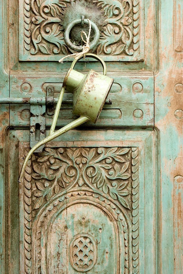 an old door handle with a watering can on it