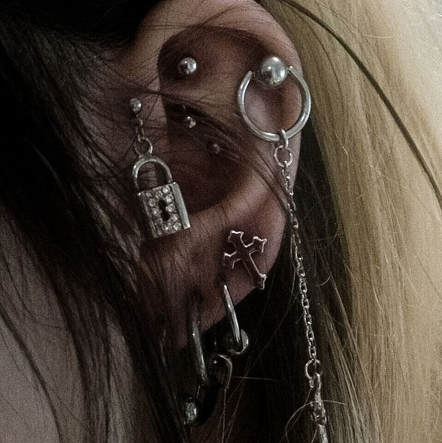 a close up of a person with ear piercings on their ears and nose rings