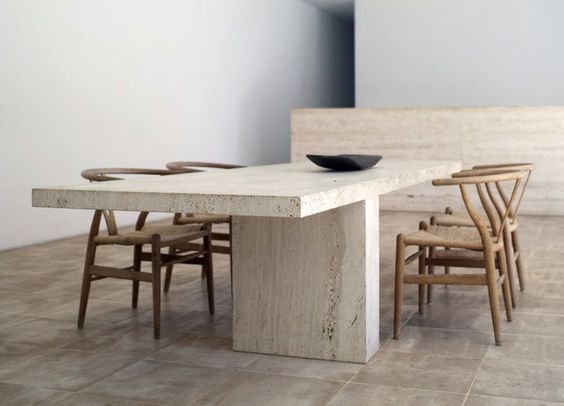 a table with chairs and a bowl on top of it in the middle of a room