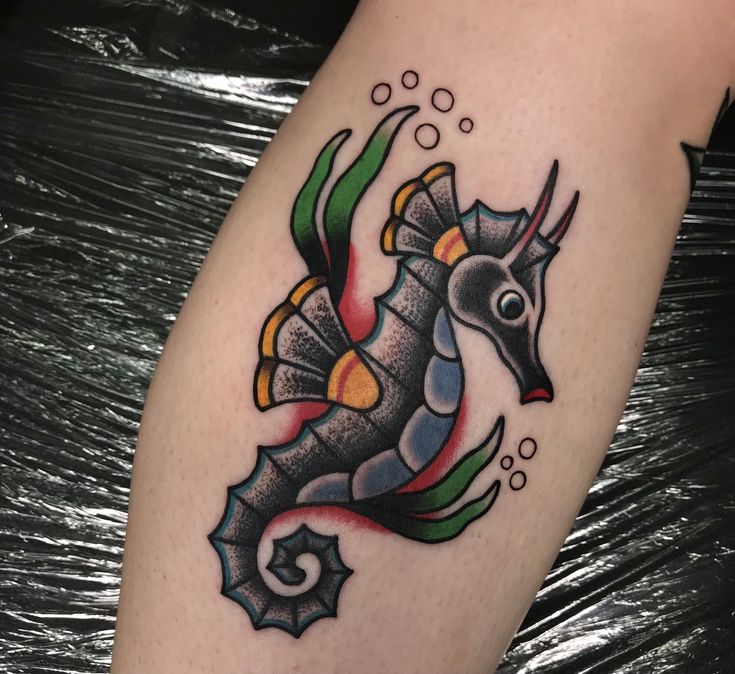 a sea horse tattoo on the leg