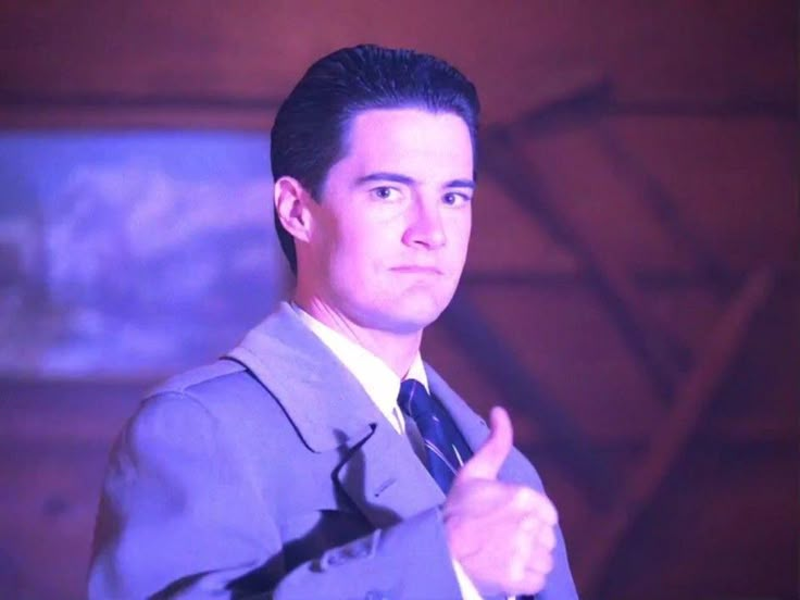 a man in a suit giving a thumbs up