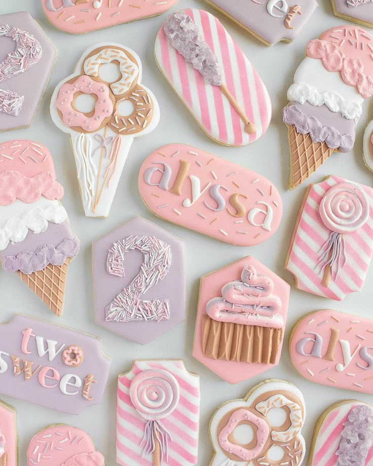 pink and purple decorated cookies are arranged on a white surface with the words sweetest written in cursive letters