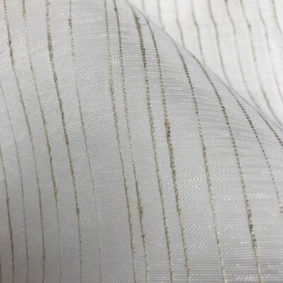 an up close shot of white fabric with gold lines on the top and bottom side