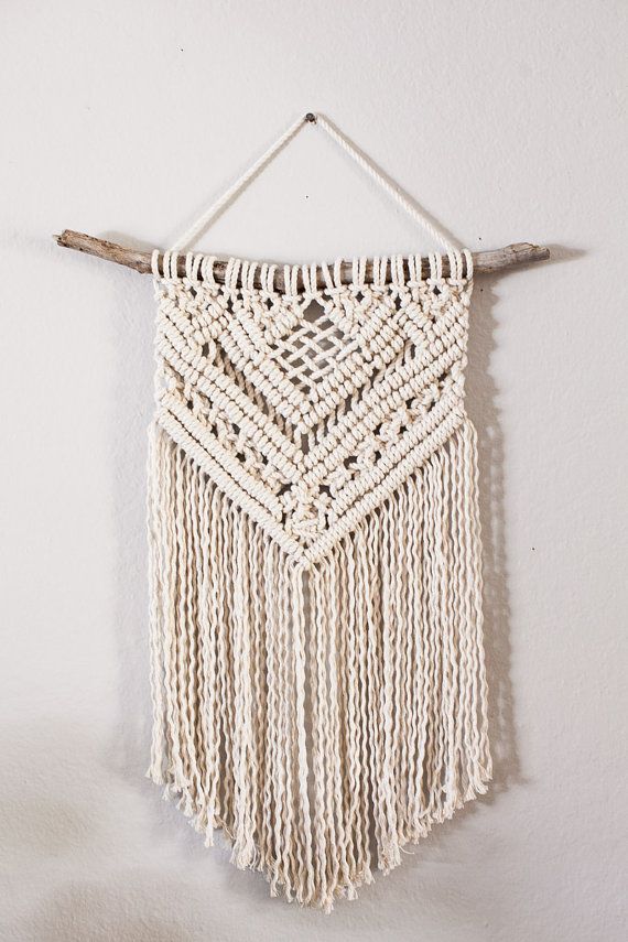 an image of a macrame wall hanging on a cell phone screen with the caption's name below it