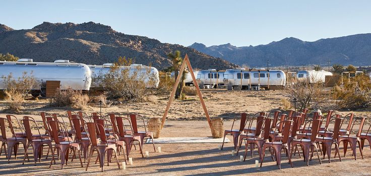 many chairs are set up in front of an rv park with mountains in the background