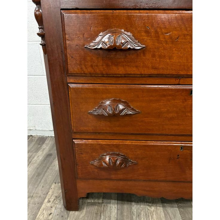 an antique wooden dresser with three drawers