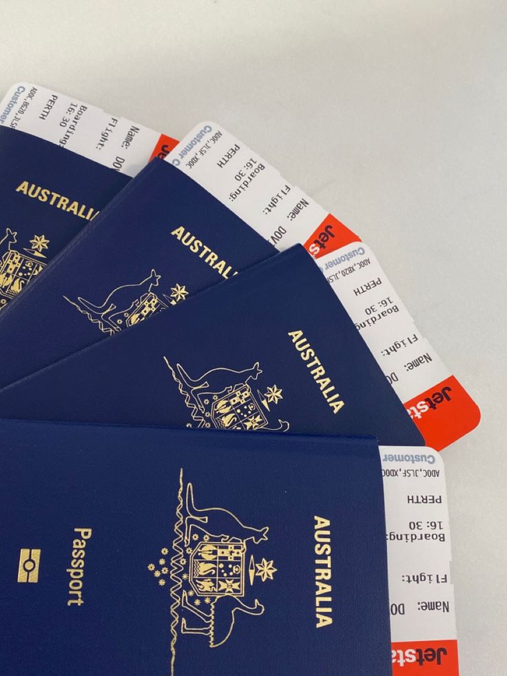 four blue australian passports sitting on top of each other