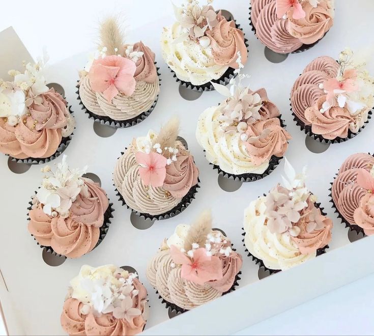 cupcakes with pink and white frosting in a box