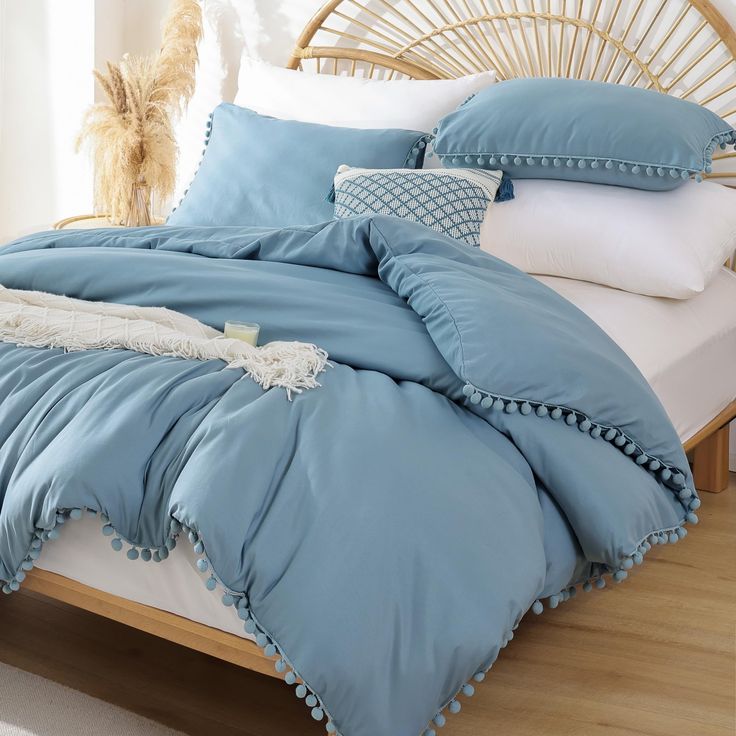 a bed with blue sheets and pillows on it