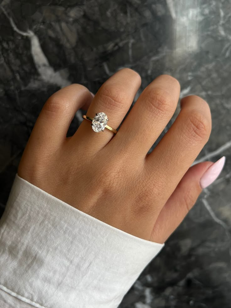 a woman's hand with a diamond ring on it